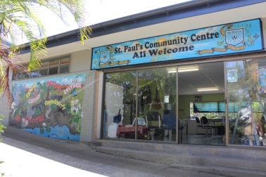 Building entrance with a sign reading “St Paul’s Community Centre – All Welcome,” featuring glass doors and colourful mural artwork along the exterior wall.